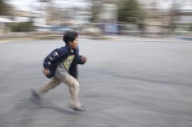 走る子供の写真。背景が流れている