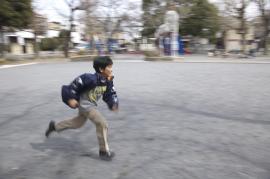 走る子供の写真。背景の流れが少ない