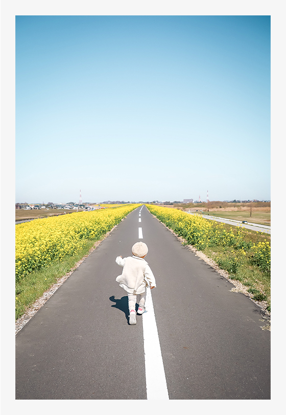 菜の花ロードを見た途端「わーい!」と喜びながら駆け出した瞬間もサッとカメラを構えて撮れてしまうEOS RPの身軽さと、ズームレンズの対応力には驚くばかり。