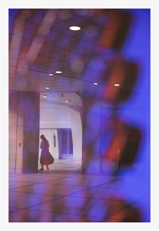 ゴンドラの広告写真を覆うガラスに映り込んだ人物を撮影しました。絞り開放F2.8で人物にピントを合わせることで、ゴンドラをぼかし、画面のざわつきを抑えるとともに奥行きを出しました。(F2.8・1/250秒・ISO640)