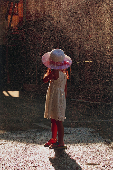 ピンク色の麦わら帽子をかぶった少女の後ろ姿