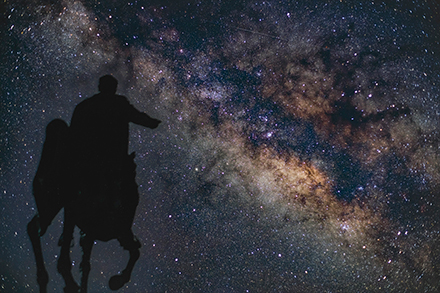 馬に乗っている人物のシルエットと星空