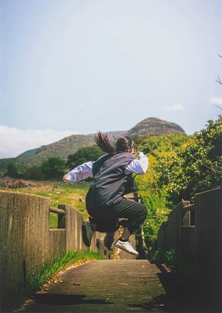 ジャンプをする女性の後ろ姿