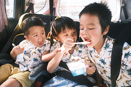 車の後部座席でアイスを食べている子供たち