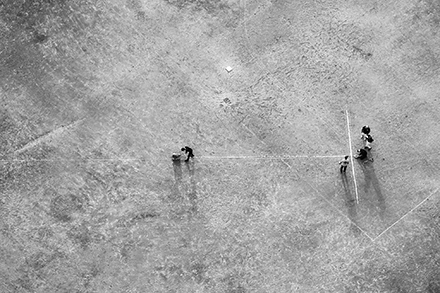 グラウンドで白線を引く人物